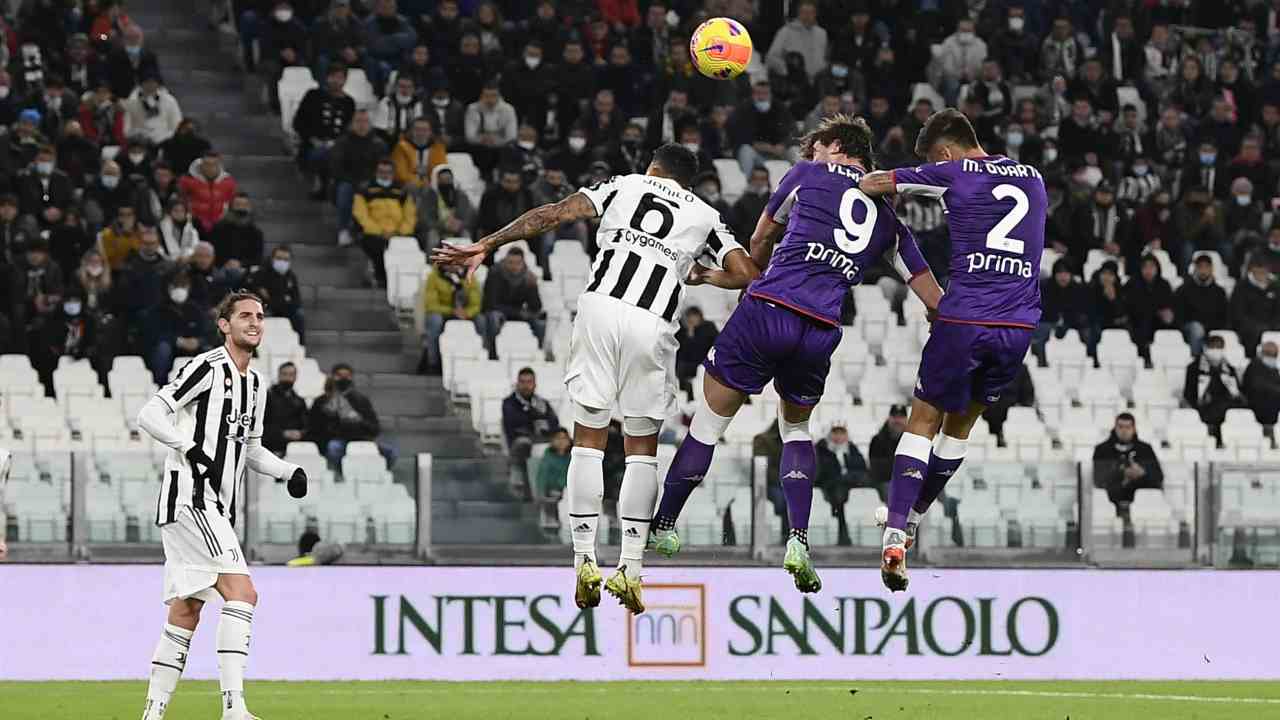 Vlahovic e Danilo saltano per colpire di testa la palla