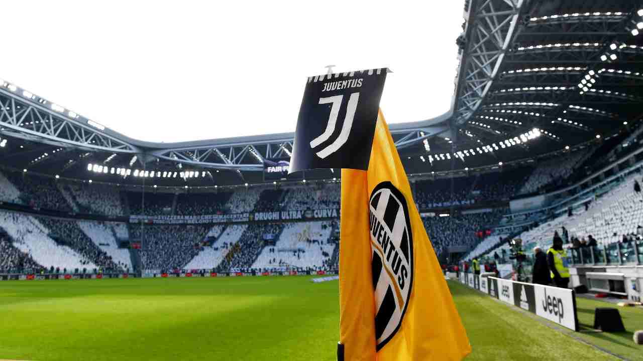 Bandierina e logo Juventus con gli spalti sullo sfondo