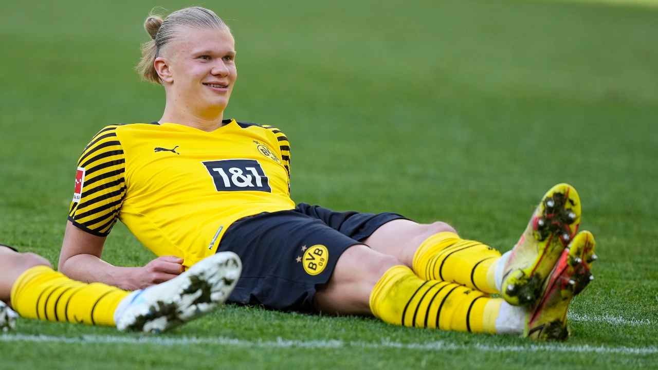 Haaland sorride steso sul campo da gioco Borussia Dortmund