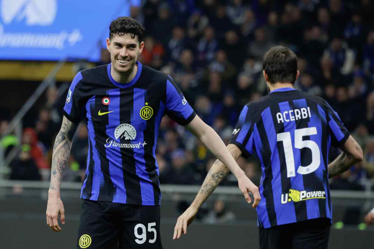 Alessandro Bastoni sorride mentre dà il 5 ad Acerbi