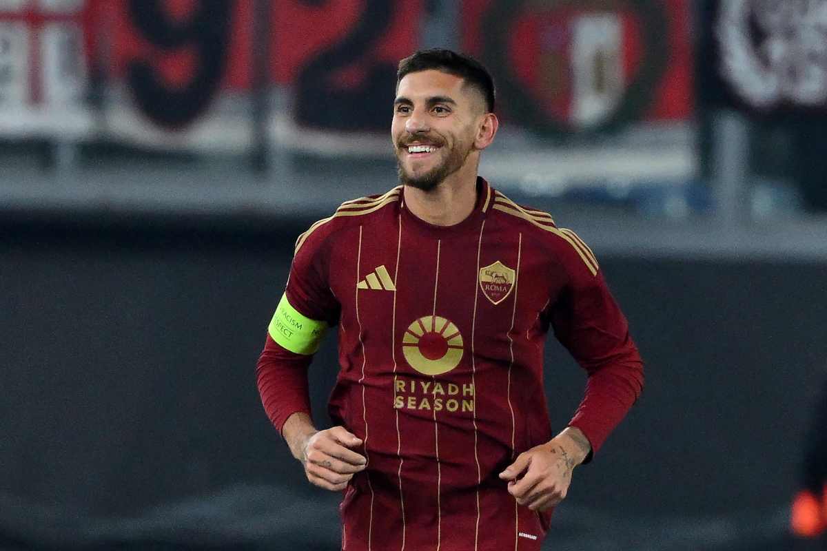 Lorenzo Pellegrini sorride con indosso la maglia della Roma e la fascia da capitano
