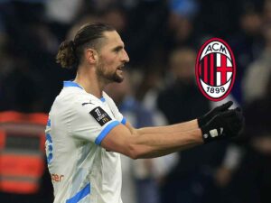 Adrien Rabiot con la maglia del Marsiglia che sembra tenere tra le mani uno scudetto del Milan