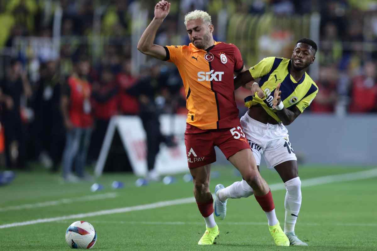 Baris Yilmaz del Galatasaray trattenuto da un calciatore del Fenerbahce