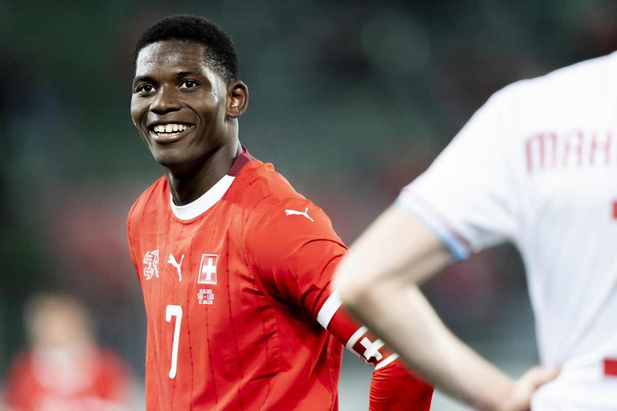 Breel Embolo sorride ai compagni con la maglia della Svizzera